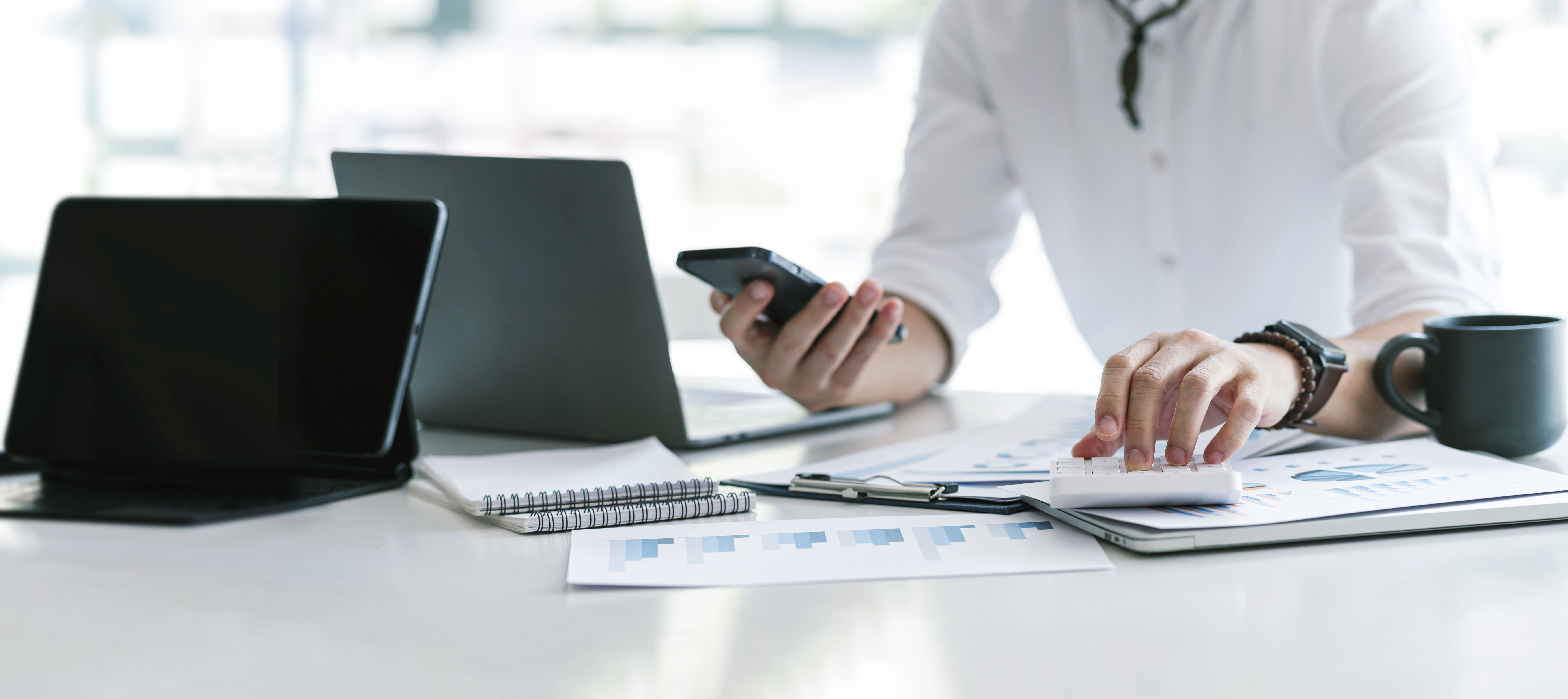 Businessman Using calculator, tablet and smartphone. Concept of business strategy financial research